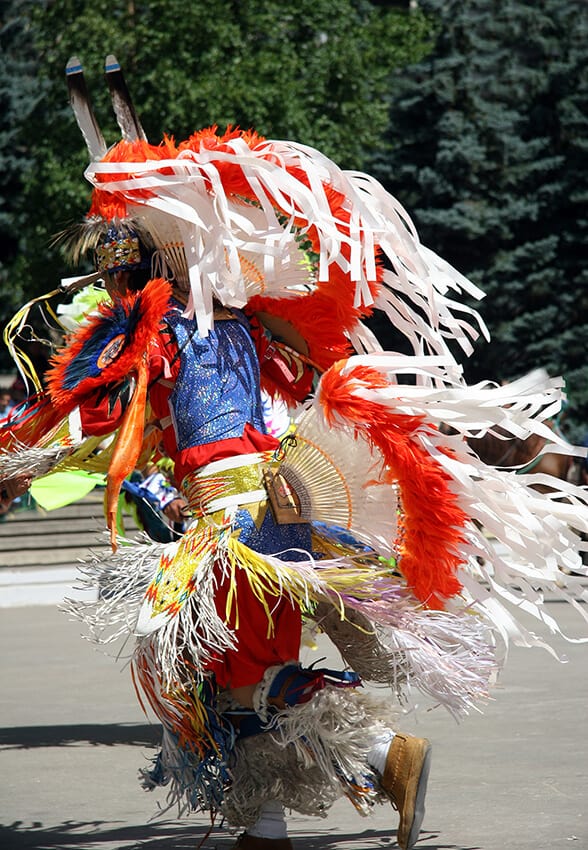 Native American indian dancing with a traditional dress during a sacred ceremony