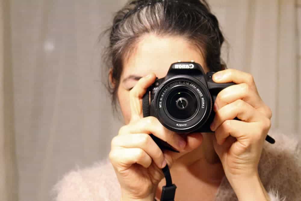 Donna scatta una foto con una fotocamera reflex Canon