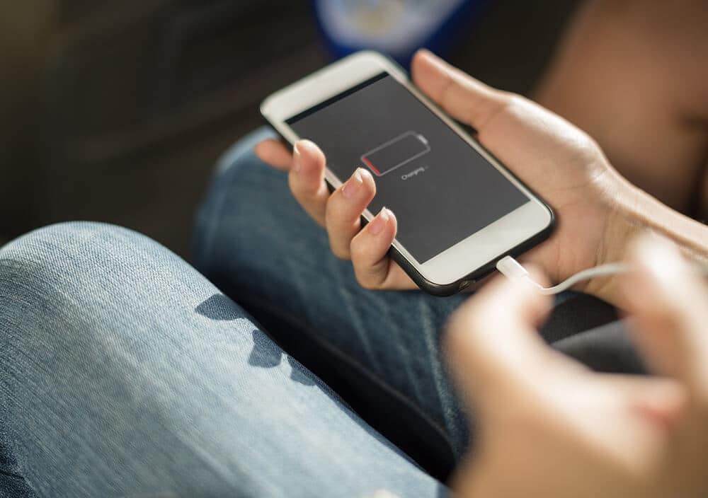 Girl recharging her iPhone using a power bank