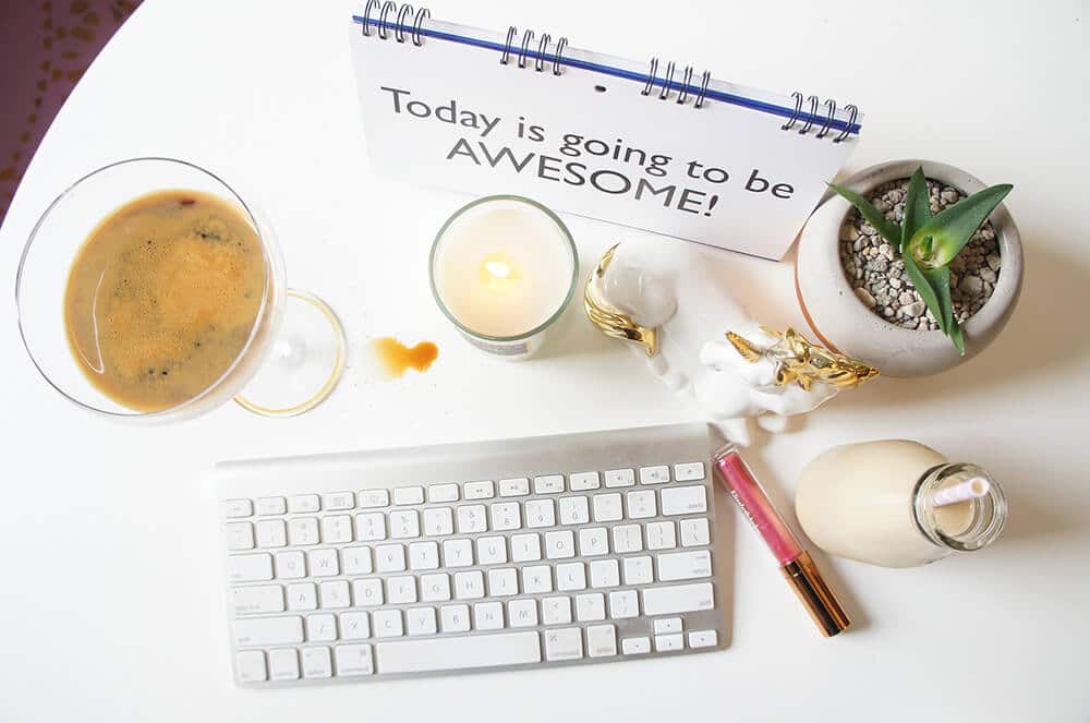 Writing desk with, keyboard, a cup of coffee and a motivational board