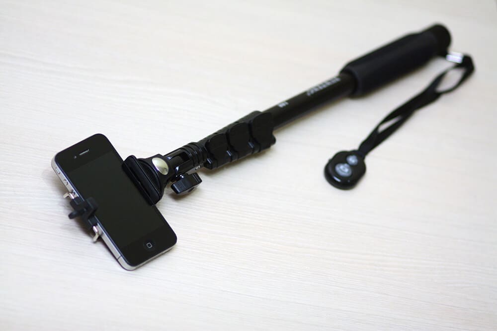 A black selfie stick with a remote
