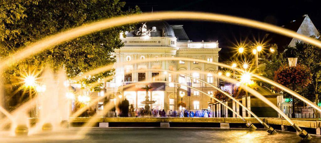 View of one of the historical buildings in Bratislava lit up at night 