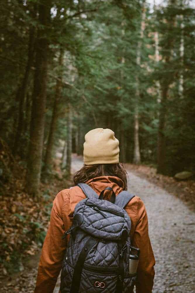 Winter hiking in a forest with warm winter clothes