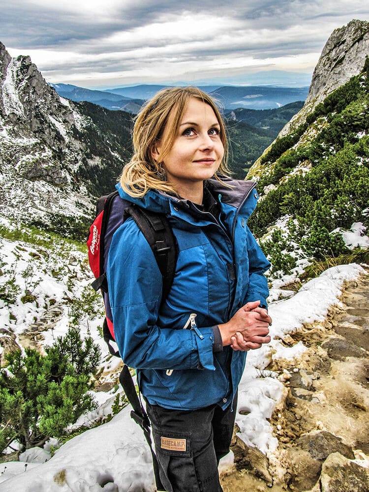 Donna con indosso abbigliamento da trekking in montagna in inverno