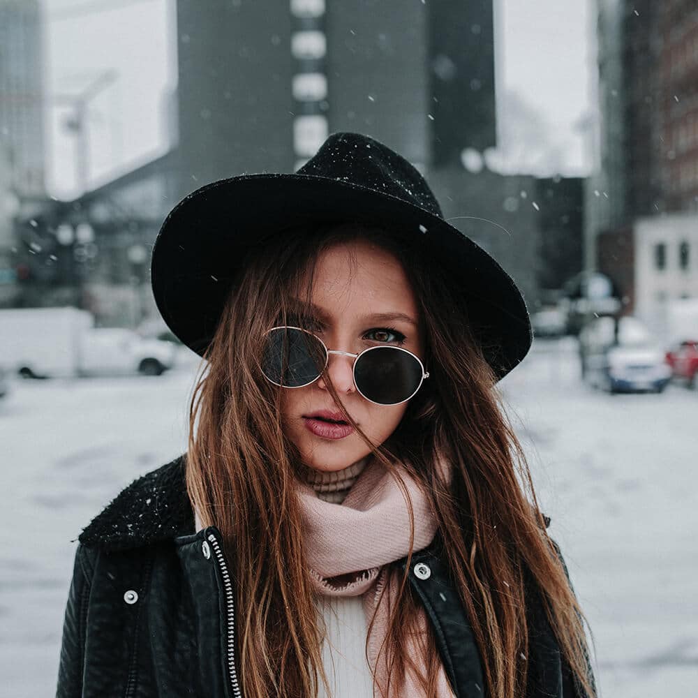 Donna con indosso occhiali da sole tondi in inverno