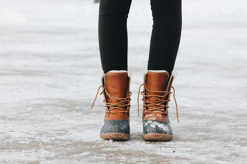 Gambe di una donna con indosso leggings e stivali invernali da neve
