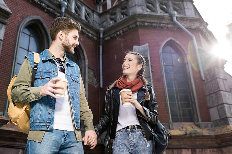 Young Couple drinking coffee in front of a train station in the Netherlands