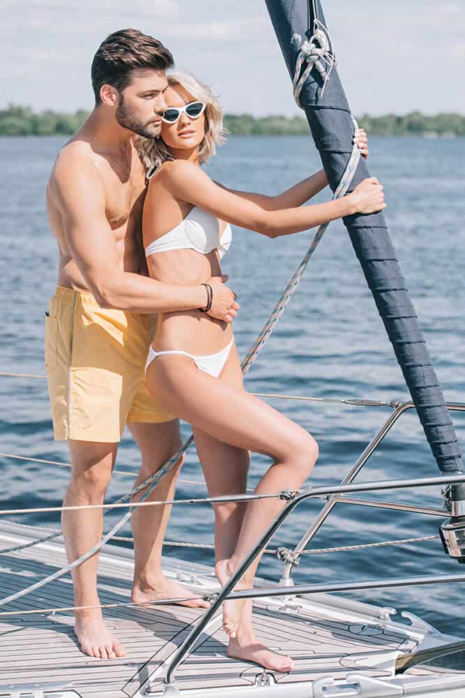Young couple hugging on a sailboat at sea