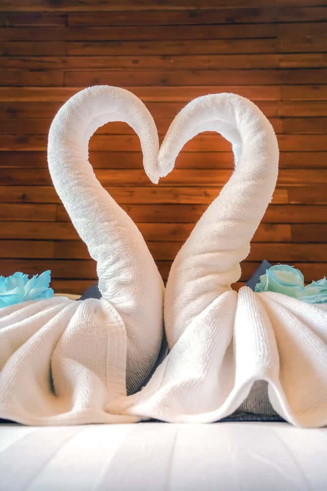Asciugamani piegati a forma di cigni che formano un cuore