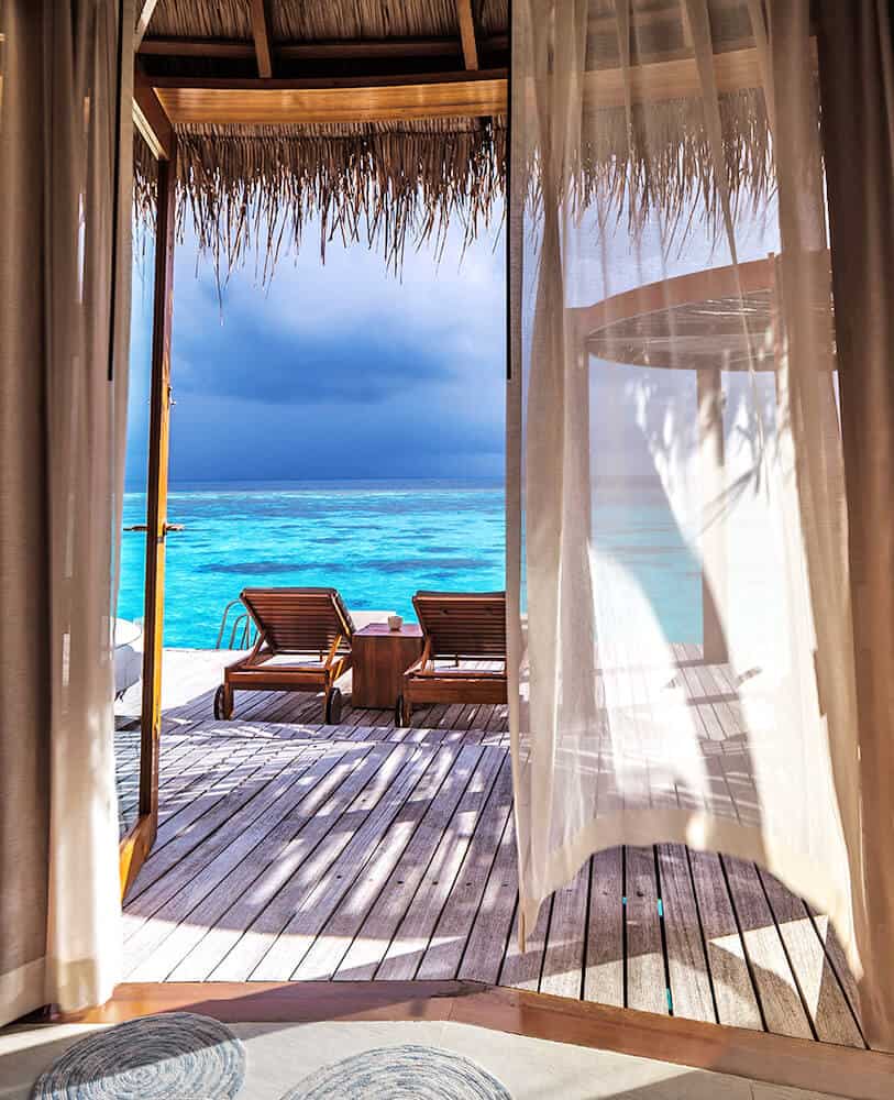 Cabana on a tripical island with two sunbeds next to the ocean