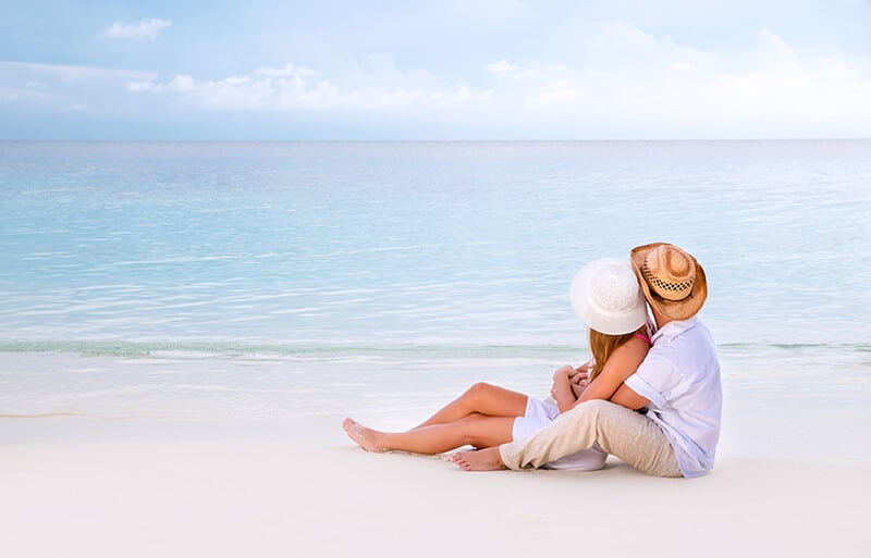 Coppia felice si abbraccia su una spiaggia tropicale