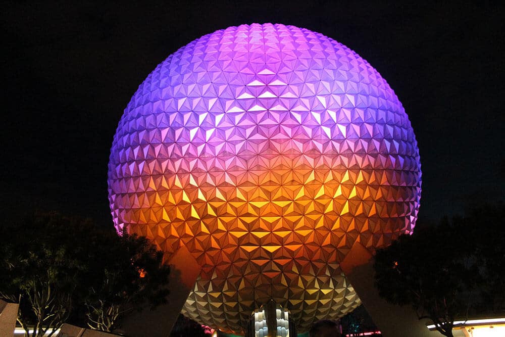 La grande sfera simbolo di Epcot illuminata di arancio, blu e lilla