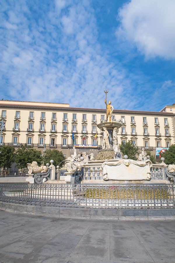 The Fontana del Tritone with Palazzo San Giacomo in the background on a summer day in Naples
