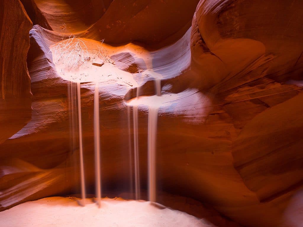 Upper vs Lower Antelope Canyon - Long exposure shot with sand falling down from the rocks inside the Upper Antelope Canyon