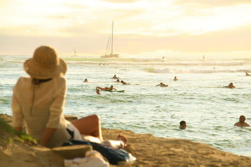 Woman enjoying a beautiful sunset on the beach, one of the things to do in Waikiki at night