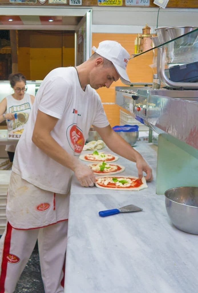 Pizzaiolo napoletano che stende la pizza