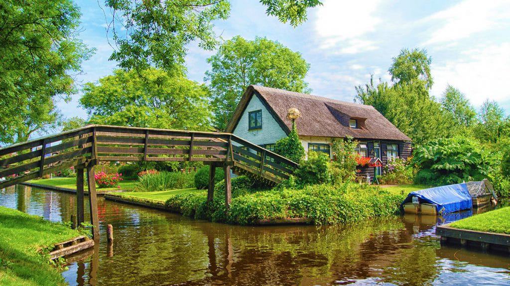 House in Giethoorn village next to a wooden bridge, on a canal