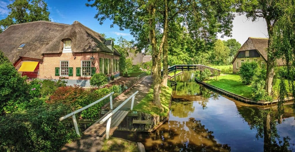 Postcard picture of Giethoorn in the Netherlands, with bridges on the canals, traditional houses and trees