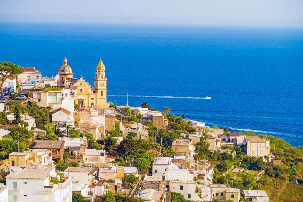 View of the famous church in Praiano with white houses on the Amalfi Coast