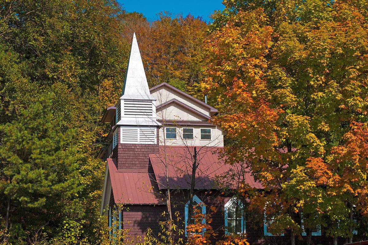 Chiesa in legno tra gli alberi in foliage autunnale negli Adirondack