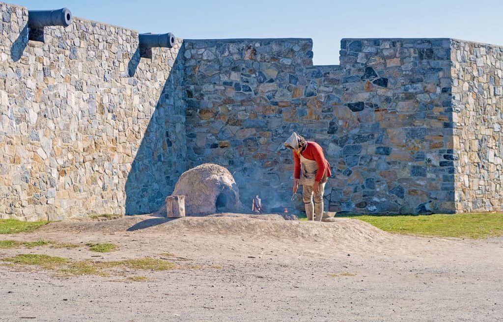 Rivisitazione storica a Fort Ticonderoga: un soldato cucina il rancio 