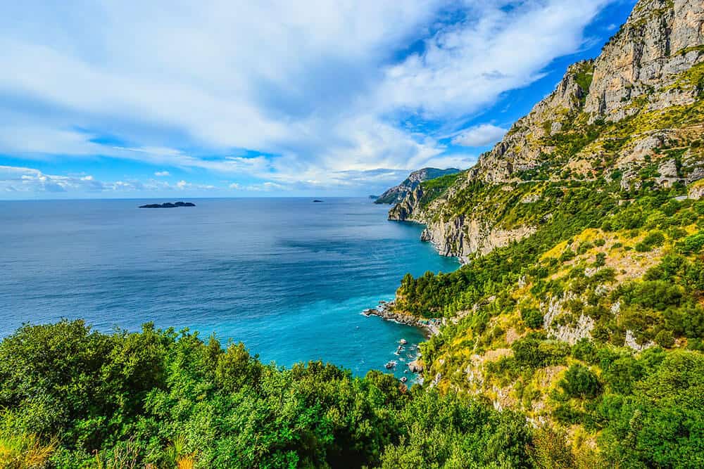 View of the Amalfi Coast on a beautiful sunny day, with turquoise water an luscious green hills