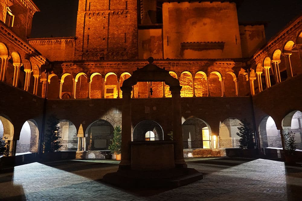 Ancient building and well in Bologna (Italy) at night