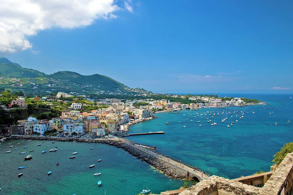 L'isola di Ischia vista dall'alto con barchette di pescatori e acque turchesi