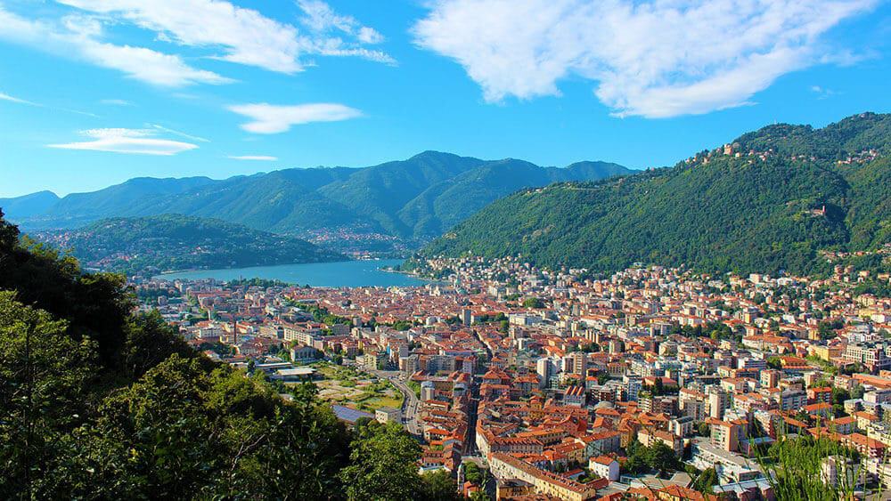 Aerial view of Lake Como, Italy, with red roofs and luscious green hills