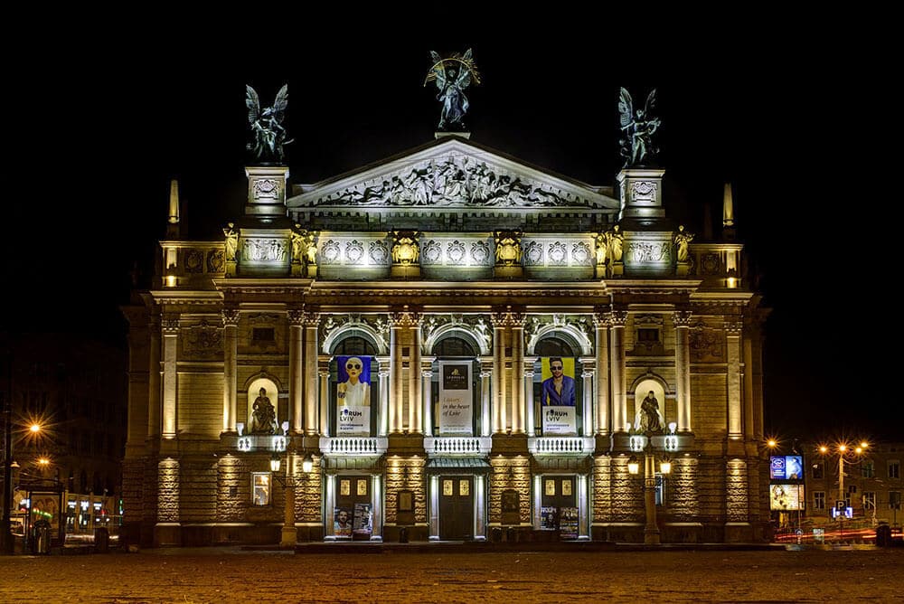 Historical building in Milan at night lit up with romantic street lamps