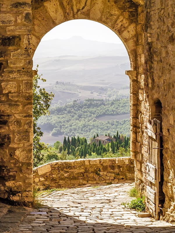 Arco in pietra che affaccia su un panorama spettacolare delle vallate toscane