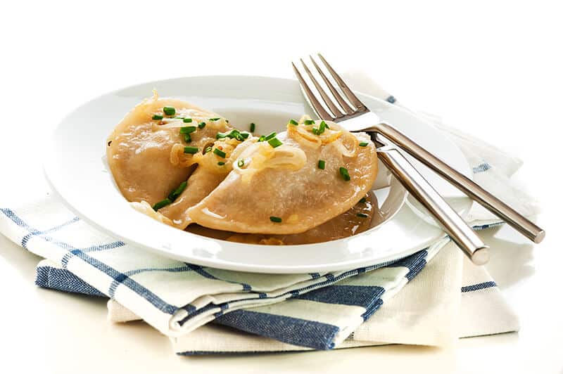 Serving of deep fried Polish pierogi with chives