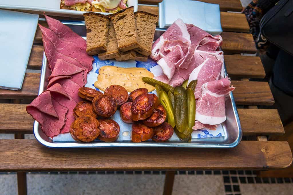 Vassoio di prosciutto di praga, cetrioli, pane, mostarda e wurstel praghesi