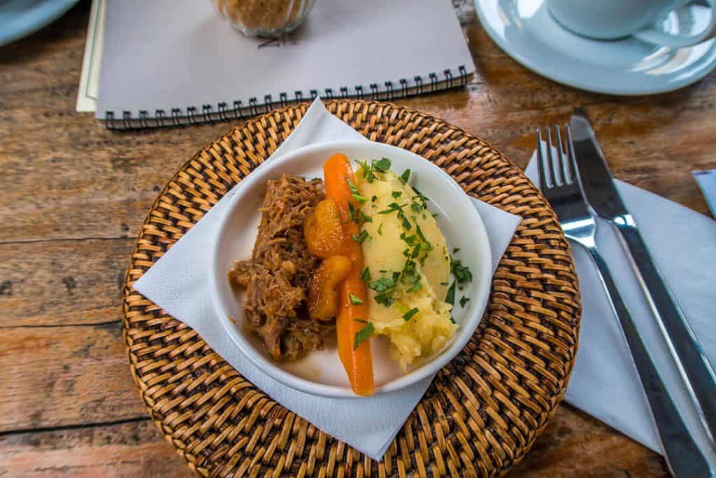 Piatto a base di agnello, carote e purea di patate con prezzemolo tritato