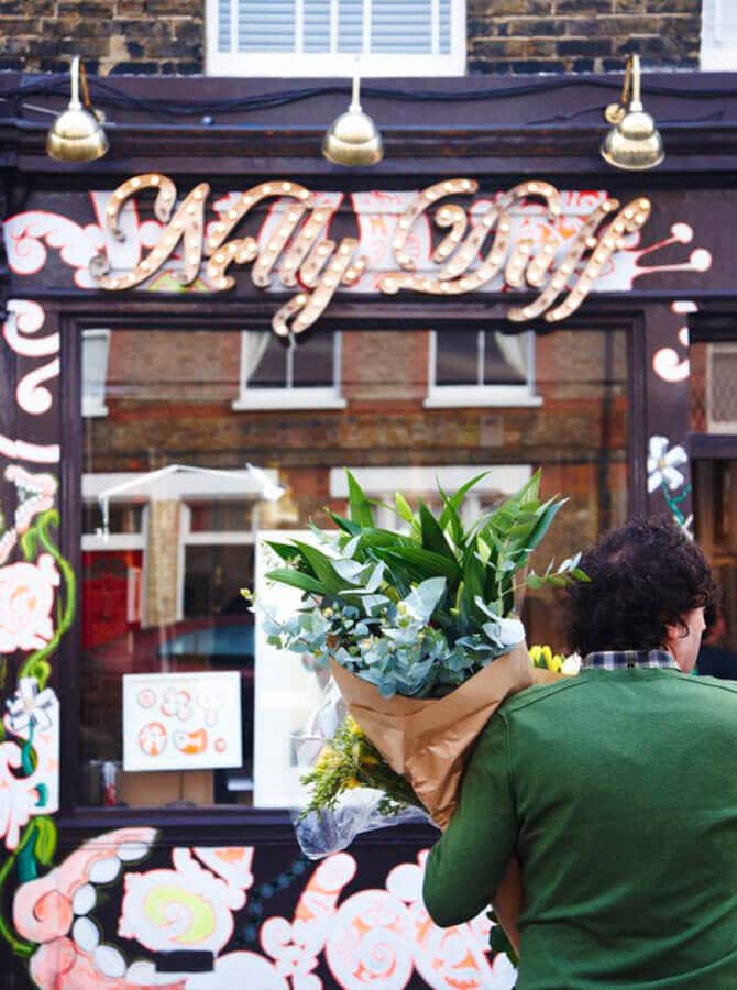 Uomo acquista un mazzo di fiori al mercatino di Columbia Road a Londra