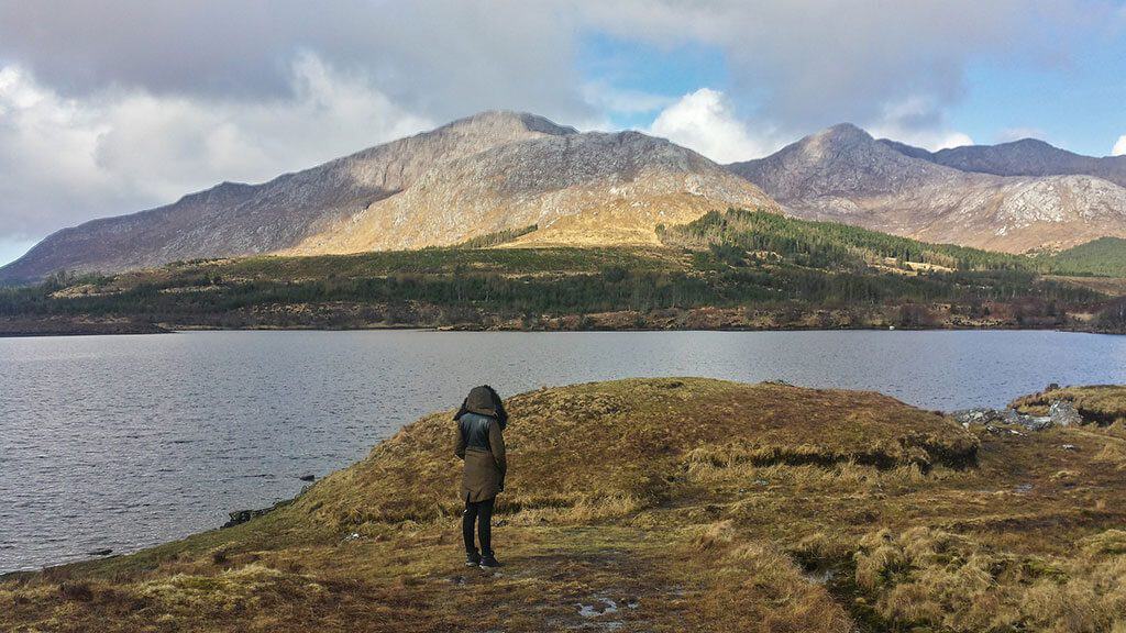 Girl staring out into space in front of a Lake in the Connemara National Park (Ireland)