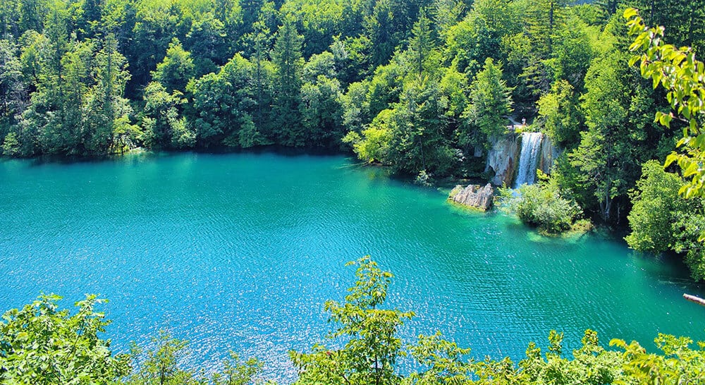 Lago turchese circondato dalle foreste nel parco di Plitvice