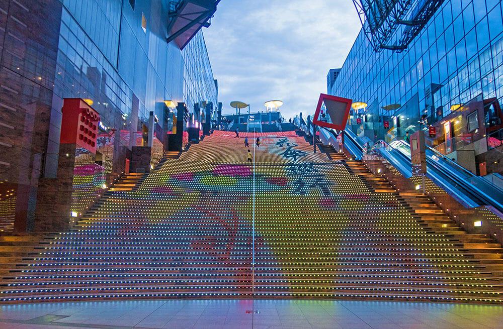 Kyoto cosa vedere in 3 giorni - luci sulle scale della stazione di Kyoto che formano l'immagine di colorati fiori di ciliegio