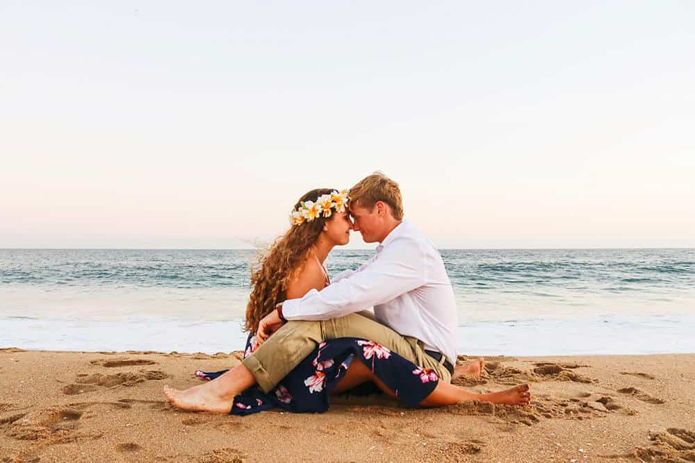 Planning a trip to Hawaii on a budget - Couple on honeymoon romancing on the beach in Waikiki Beach