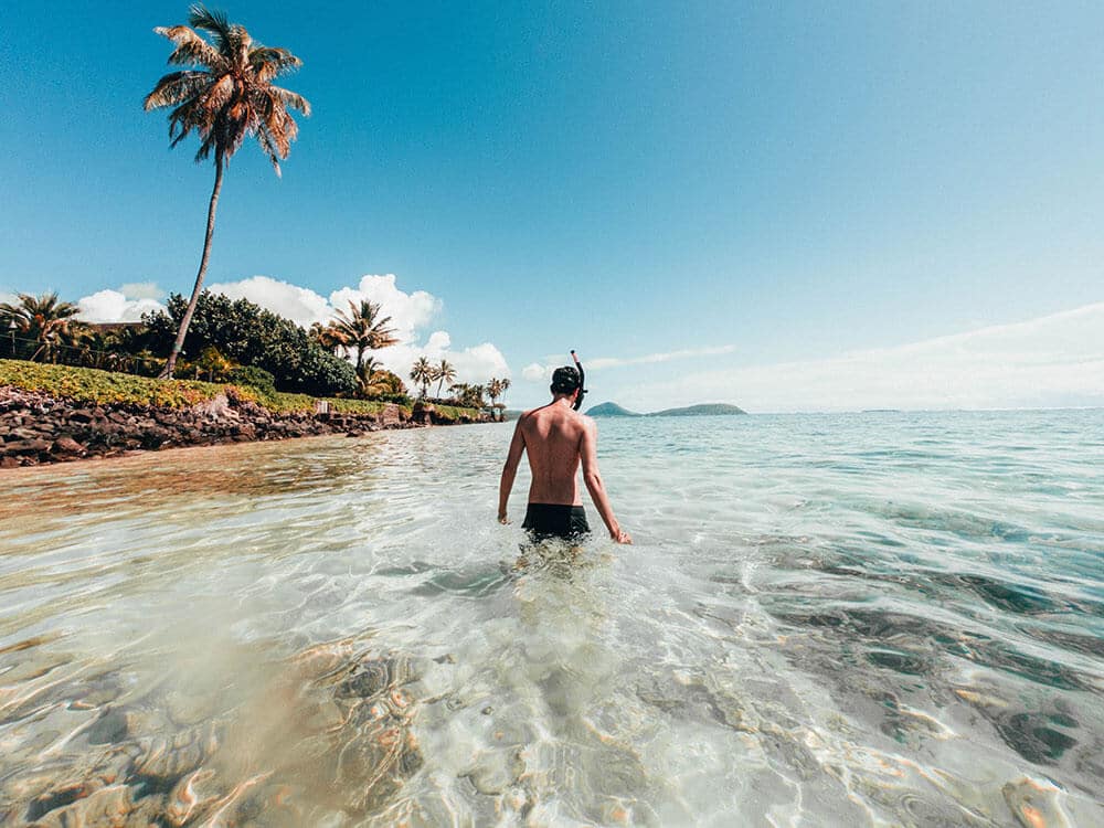 Viaggio alle Hawaii - Uomo in procinto di fare snorkeling nell'oceano vicino a Waikiki