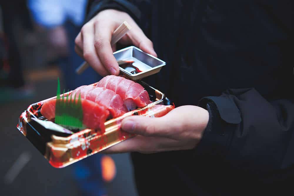 Best souvenirs from Japan - Man eating sushi from a bento