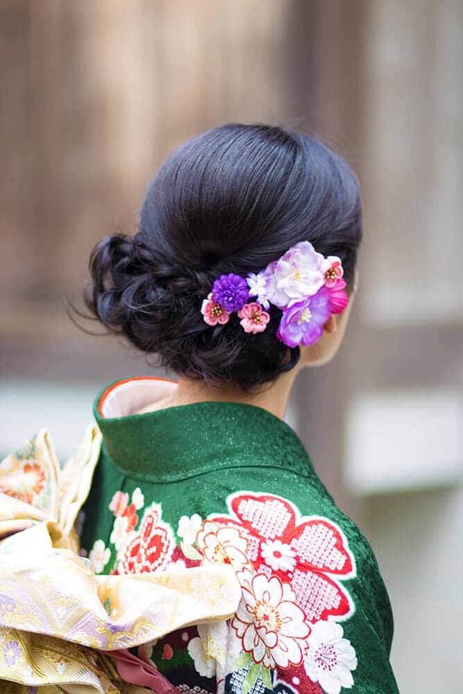 Cosa comprare in Giappone - una Maiko con indosso un kimono colorato mostra gli ornamenti fioriti nei suoi capelli