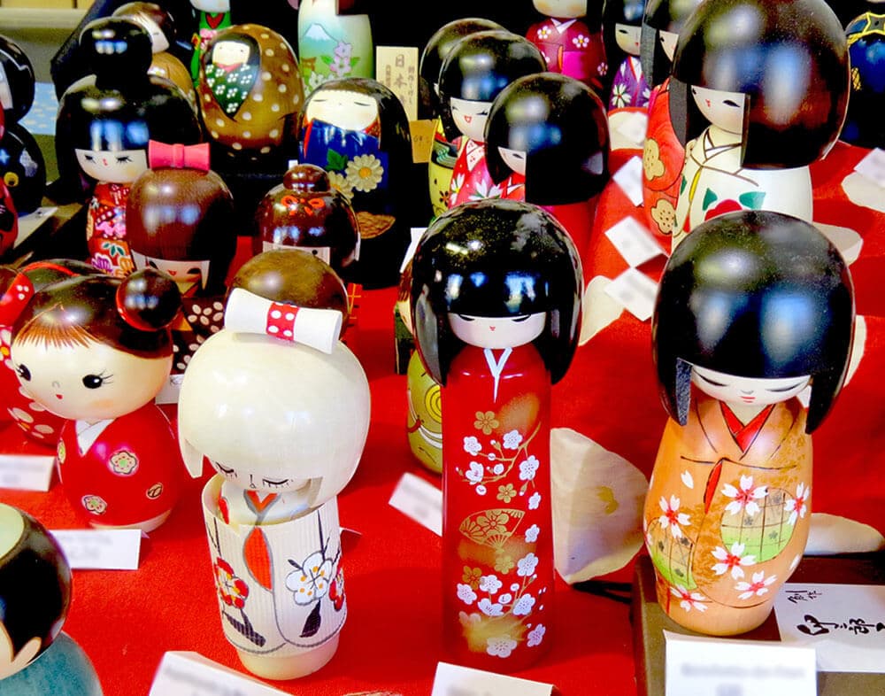 Cosa comprare in Giappone - Bambole kokeshi in un negozio, tutte diverse e in colori brillanti