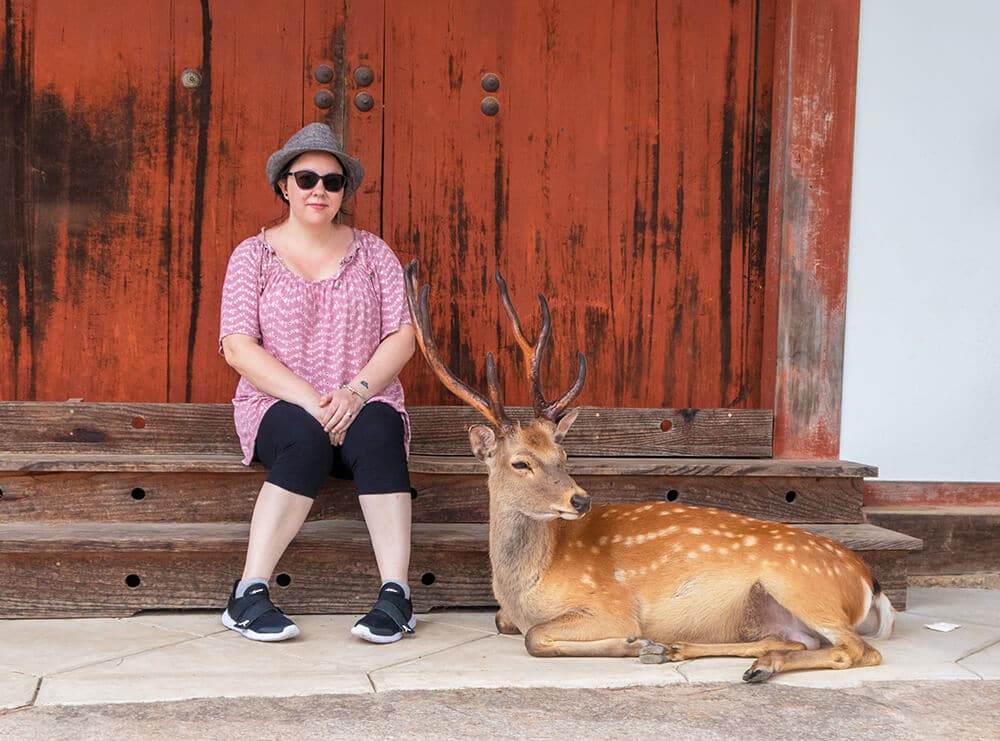 Day trip to Nara - Dany sitting next to a huge male deer at Todaiji Temple