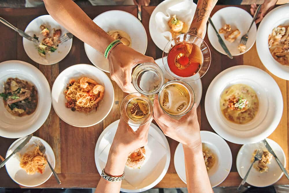 Friends toasting over an Italian dinner with different dishes spread on the table