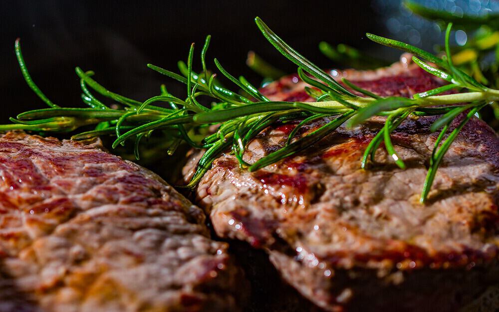 Charbroiled Fiorentina steak with a rosemary branch on the top