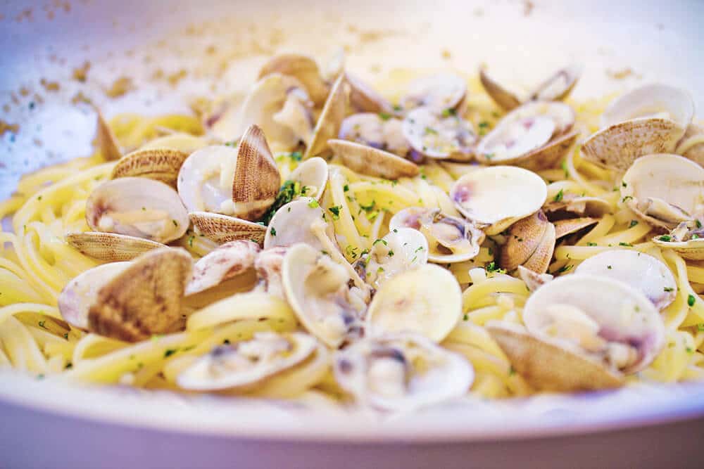 Un piatto di linguine con vongole e una spolverata di prezzemolo fresco