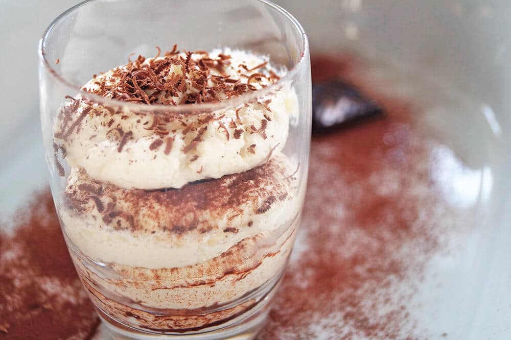 Tiramisù in un bicchiere ricoperto di scaglie di cioccolato