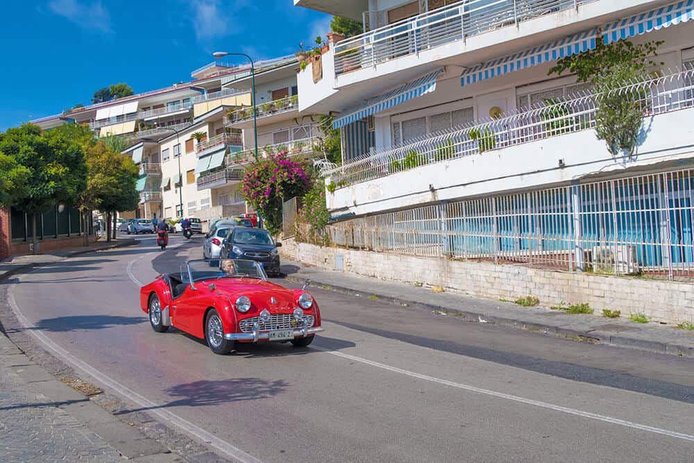 Vintage red car speeding on the Posillipo hill (Naples)