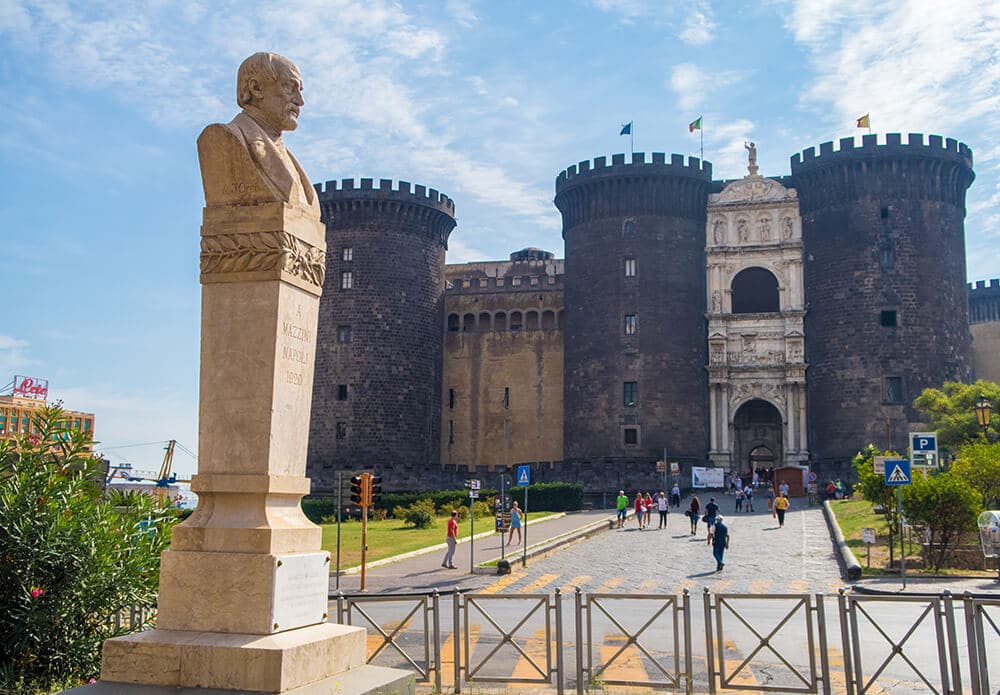 Best things to do in Naples Italy | Giuseppe Mazzini statue with the Maschio Angioino castle in Naples Italy